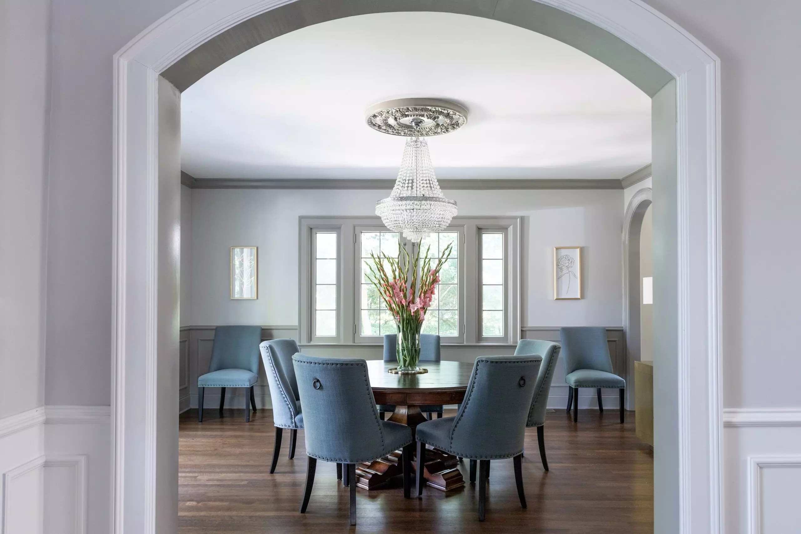 A traditional dining room with a plaster detail on the ceiling around the chandelier