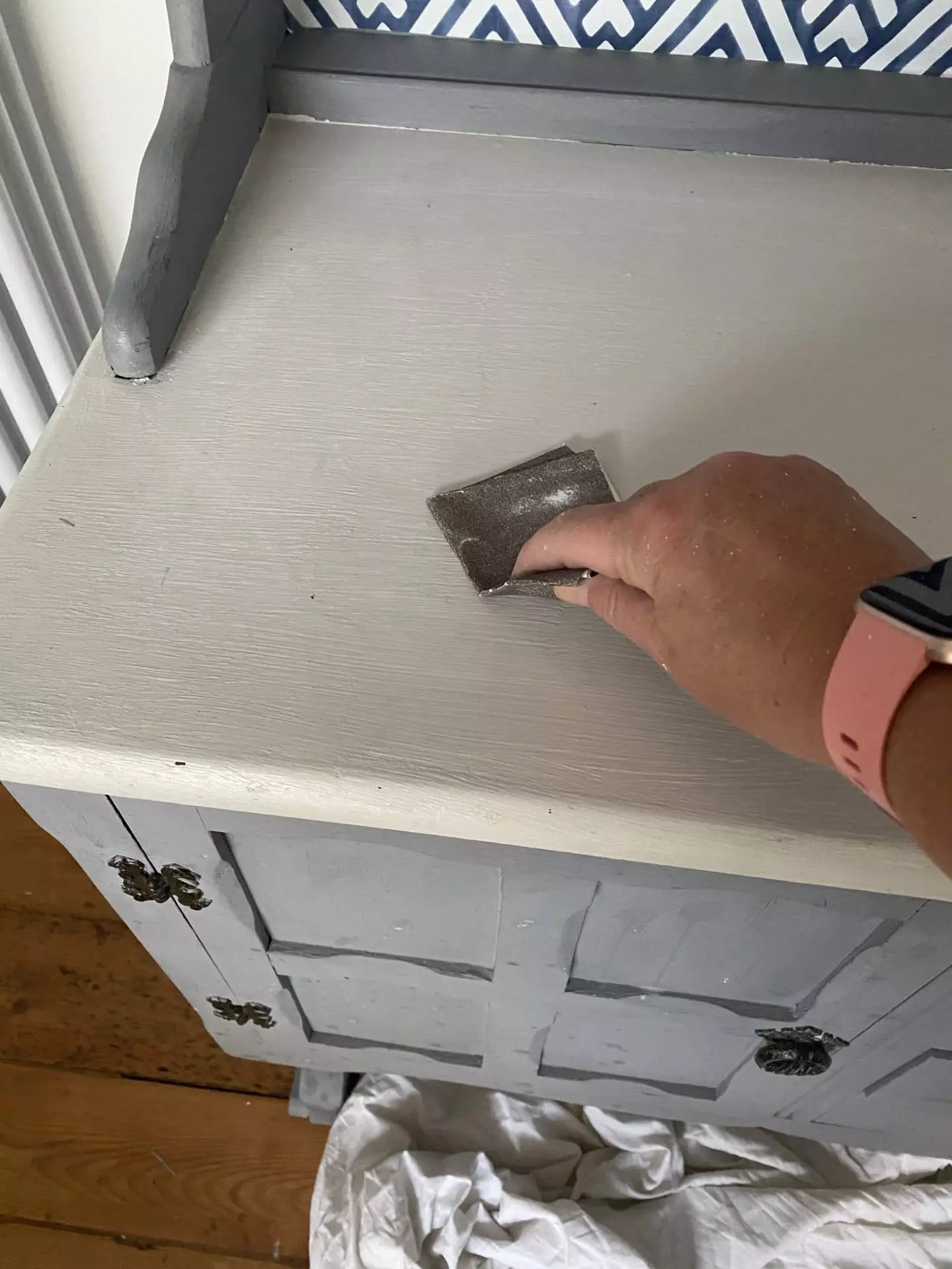 Using very fine sandpaper to leave a smooth finish on the dresser.