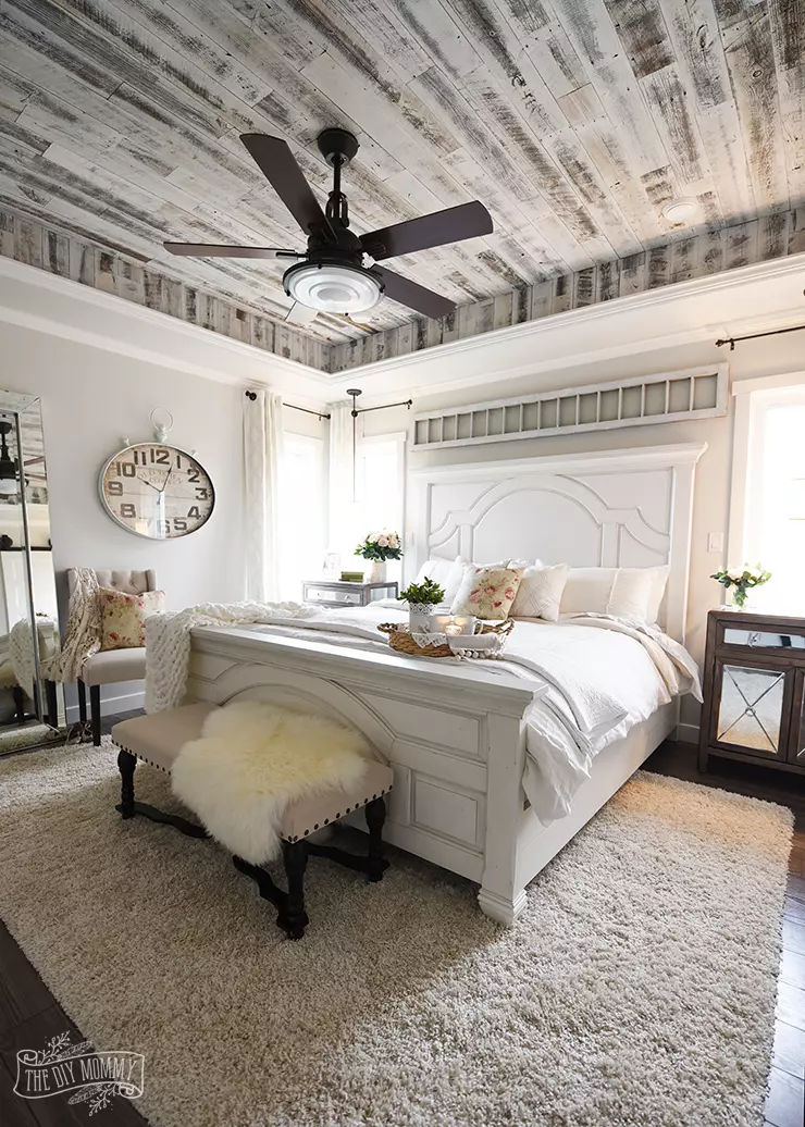 A serene grey and white master bedroom with DIY pillows.