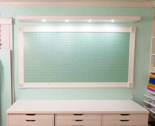 A 78" Lack shelf with puck lights over a pegboard