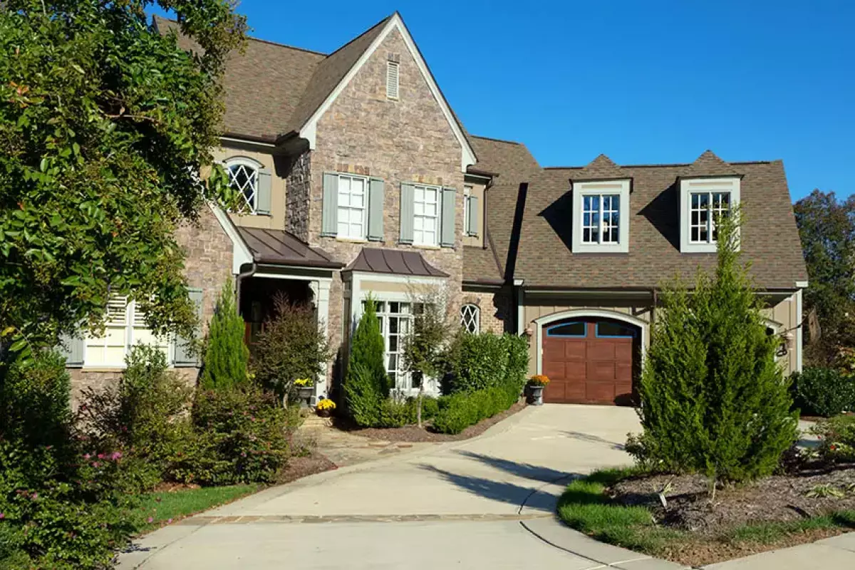 French country style house with two car garage and long driveway