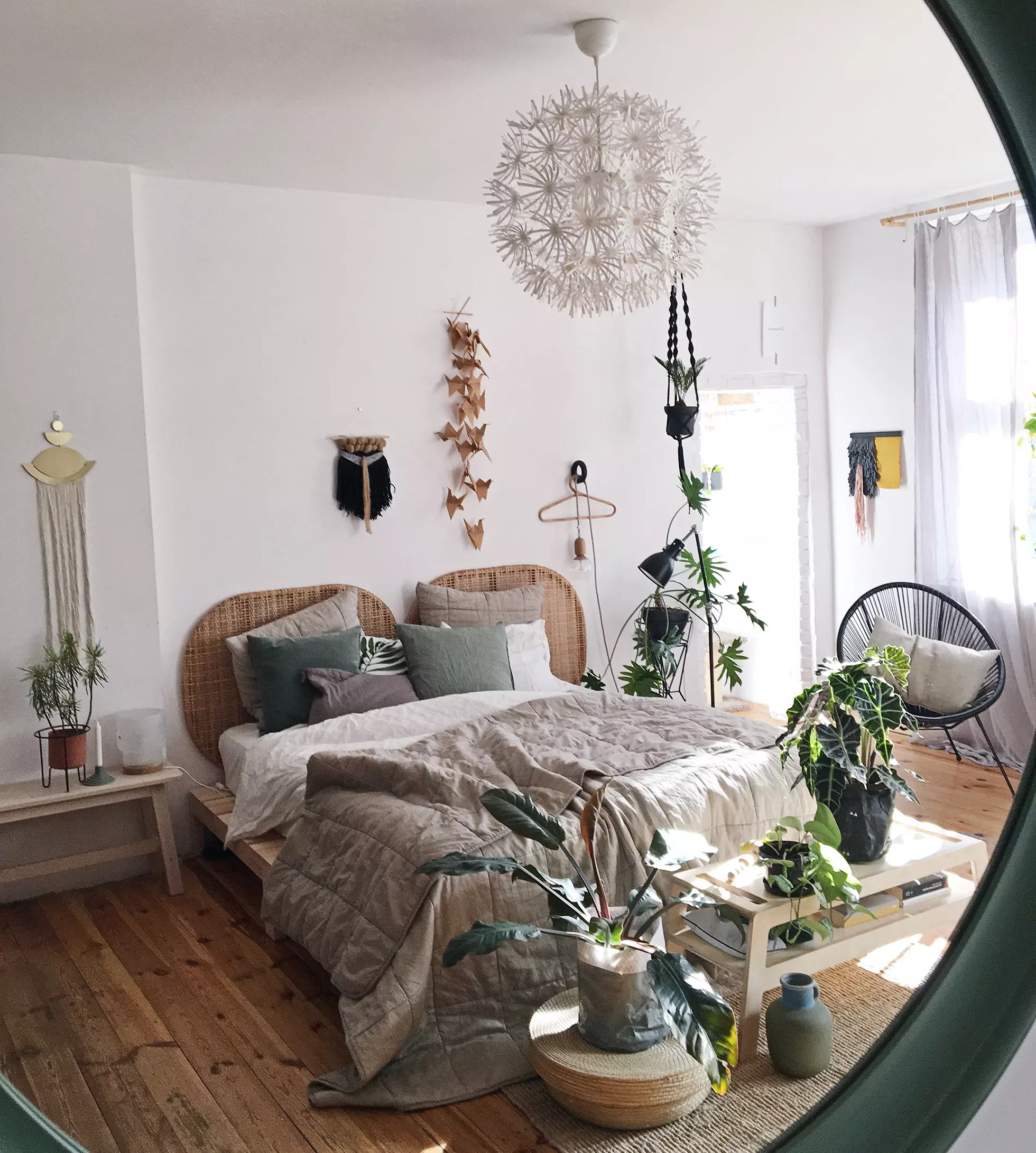 View of boho bedroom with southern exposure in mirror