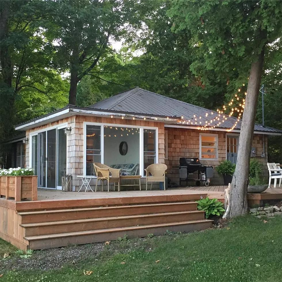 Back deck with grill, chairs of wood cottage home in summer