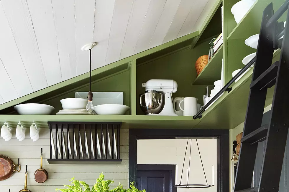 Kitchen with built-in rafter shelving and library ladder