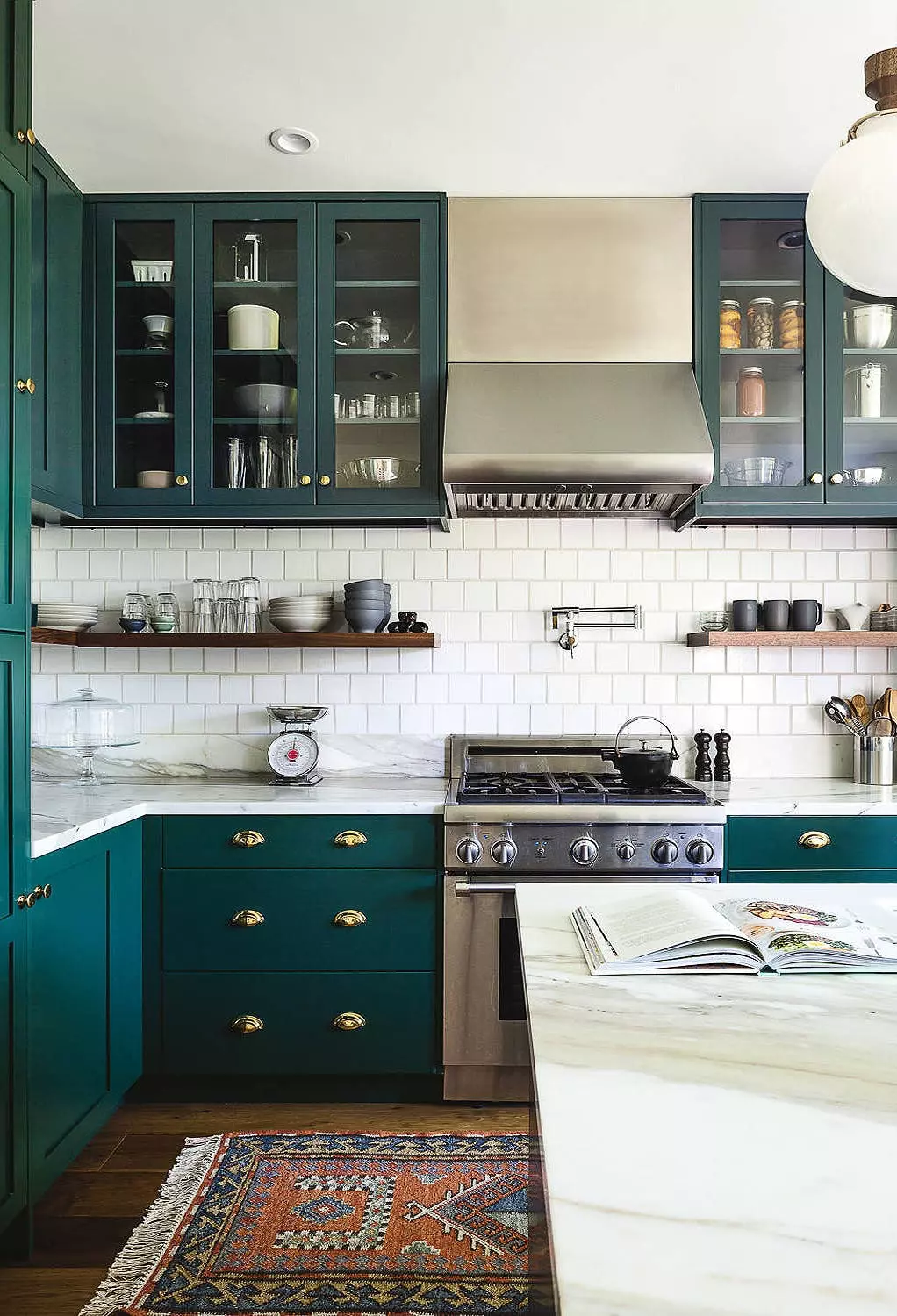 dark green kitchen cabinets paired with gold hardware