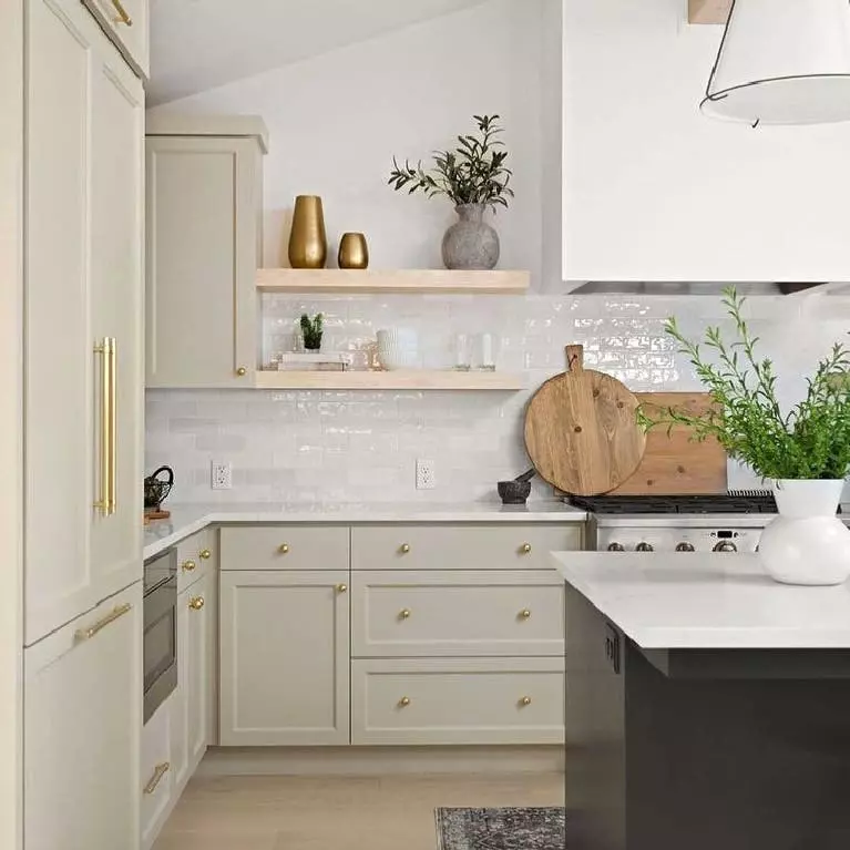 Farmhouse kitchen with pastel green cabinets, white countertops and farmhouse sink