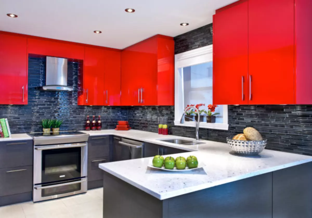 a unique combination between bright red wall cabinets and black matchstick tile backsplash