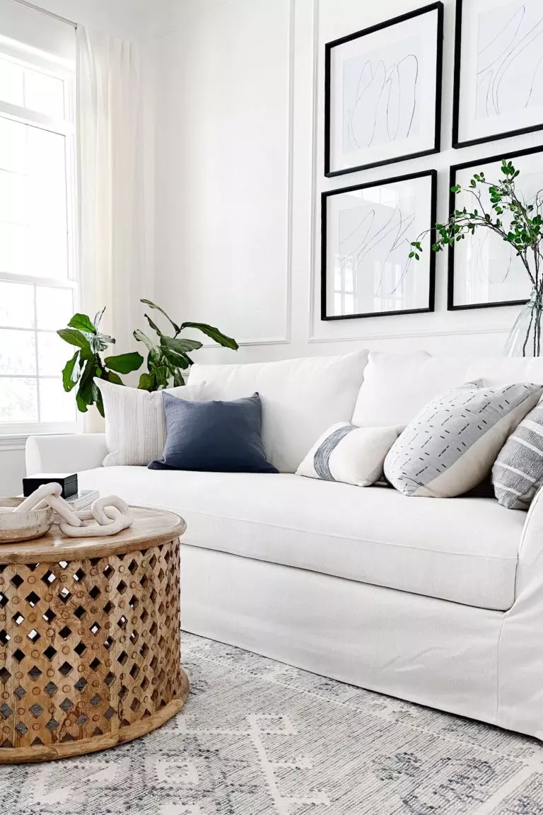 Modern coastal living room with white Ikea Farlov slipcovered sofa and round wood coffee table - jane at home
