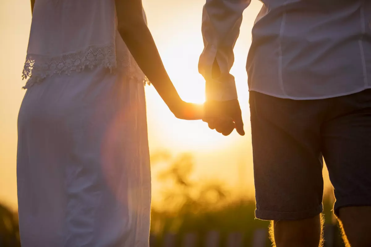 Couple holding hands at sunset