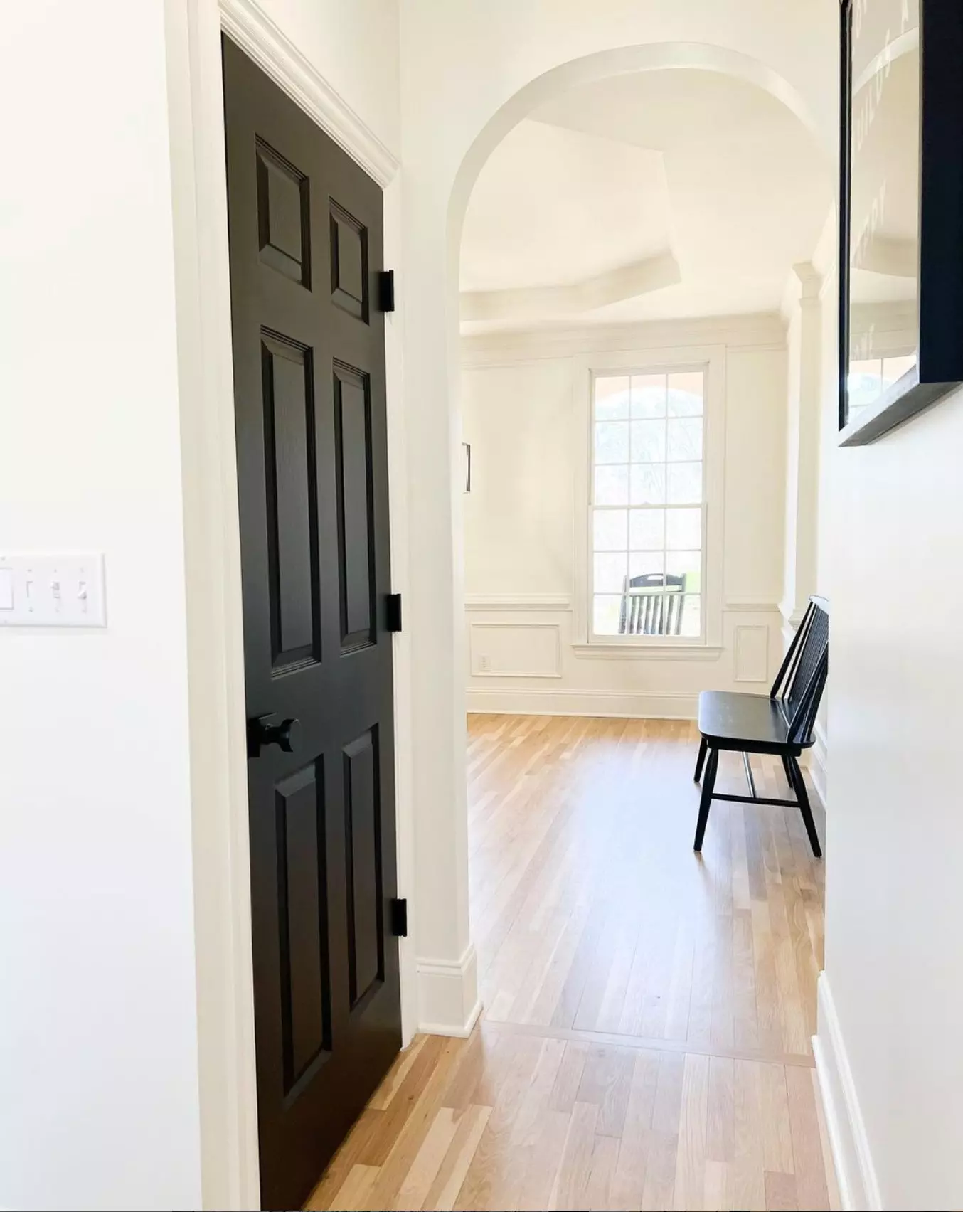 hallway with a black bench and door. The walls are painted with White Dove