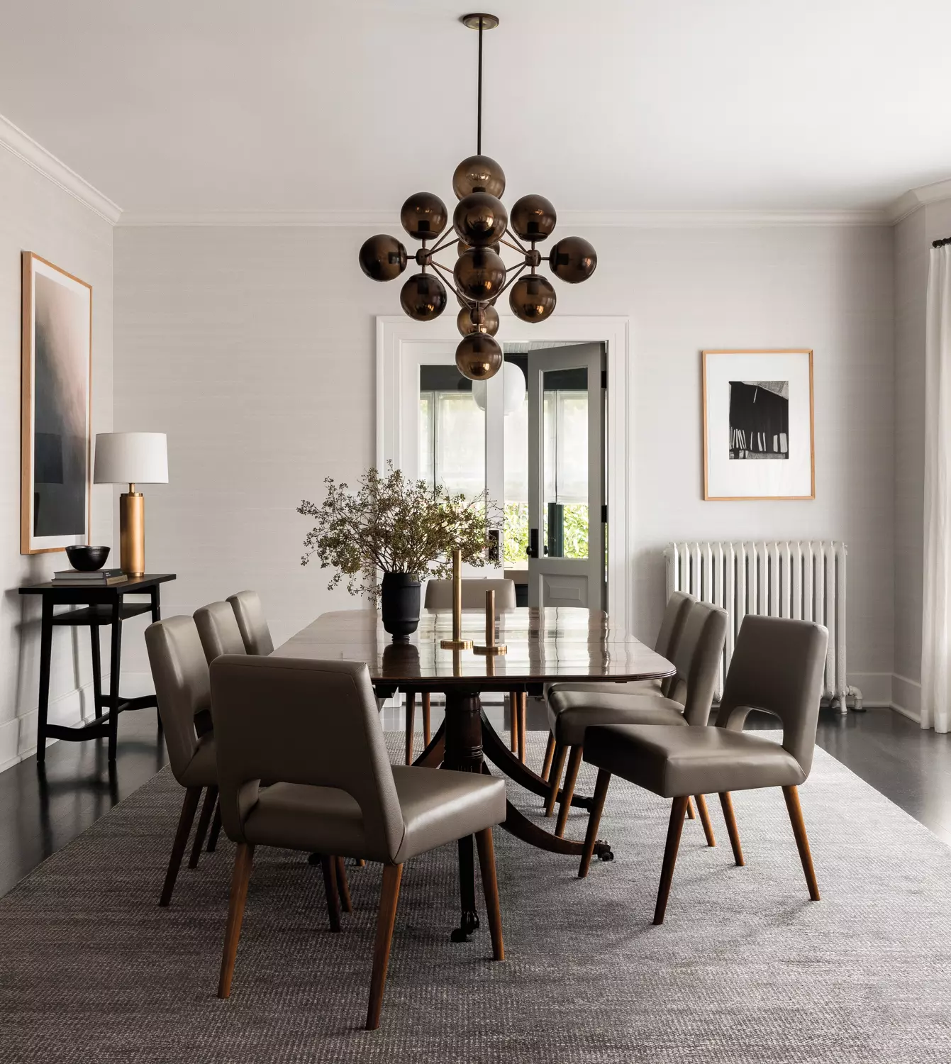 Dining room featuring a chandelier with smoked globes, long table and chairs