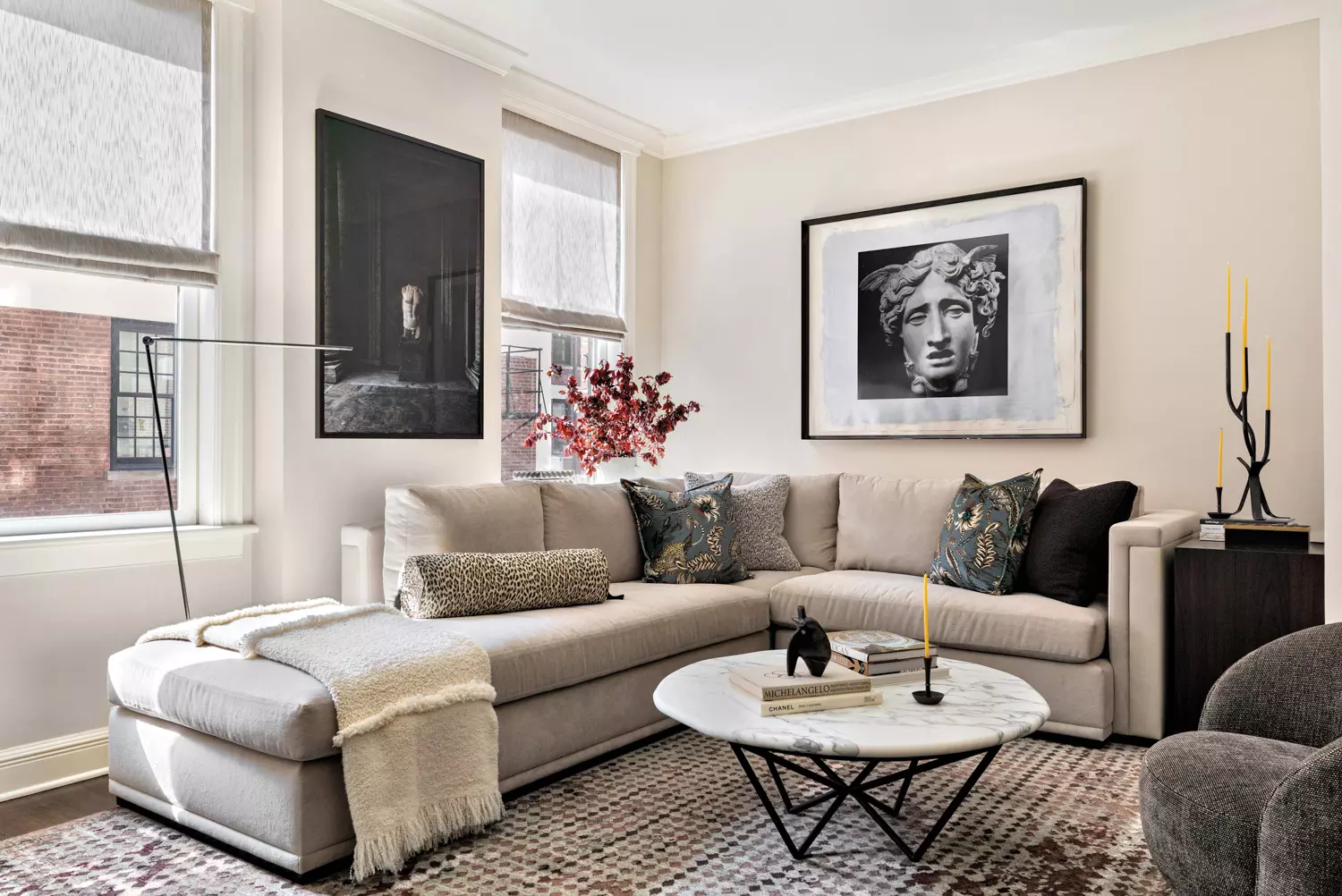 living room with gray sectional, black-and-white artworks and marble table