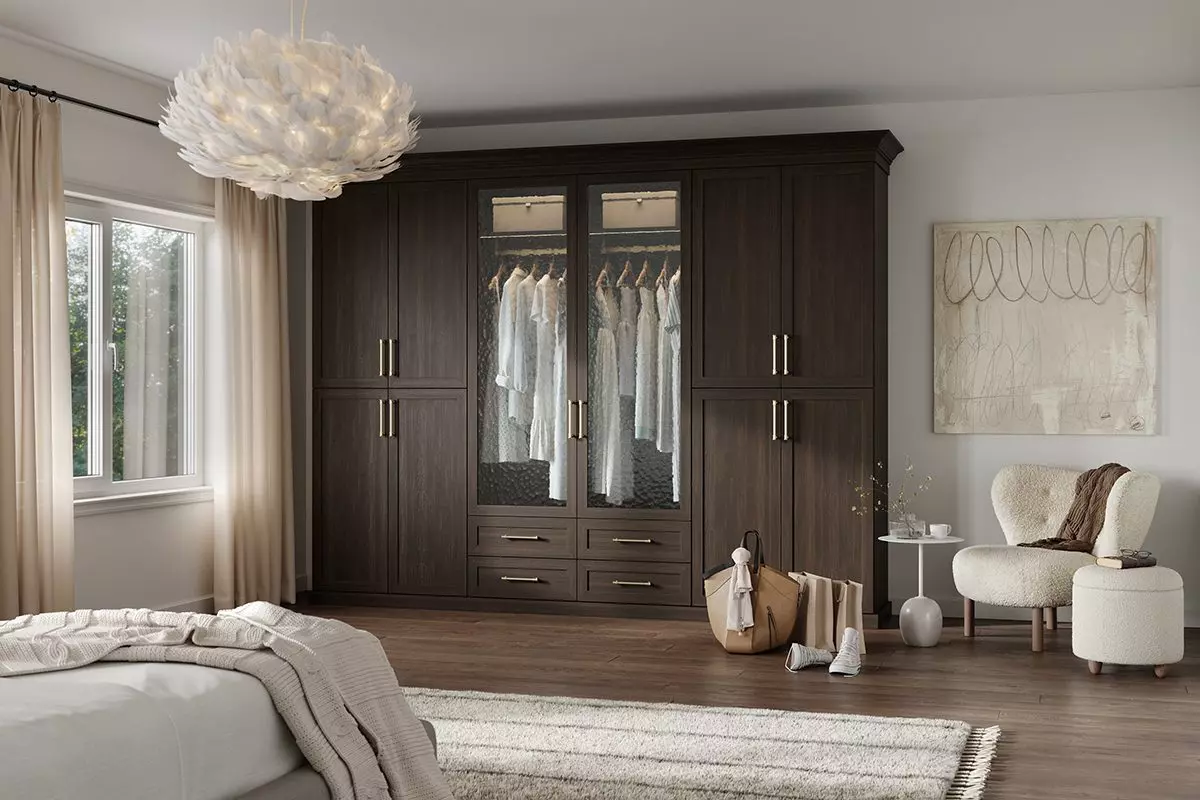 Wardrobe custom built with cabinet glass doors and drawers in dark brown wood grain finish created by California Closets