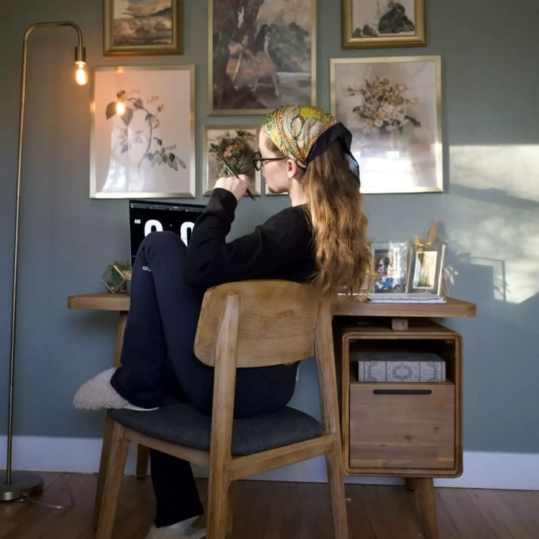 A person sitting at their matching wooden desk and chair set.