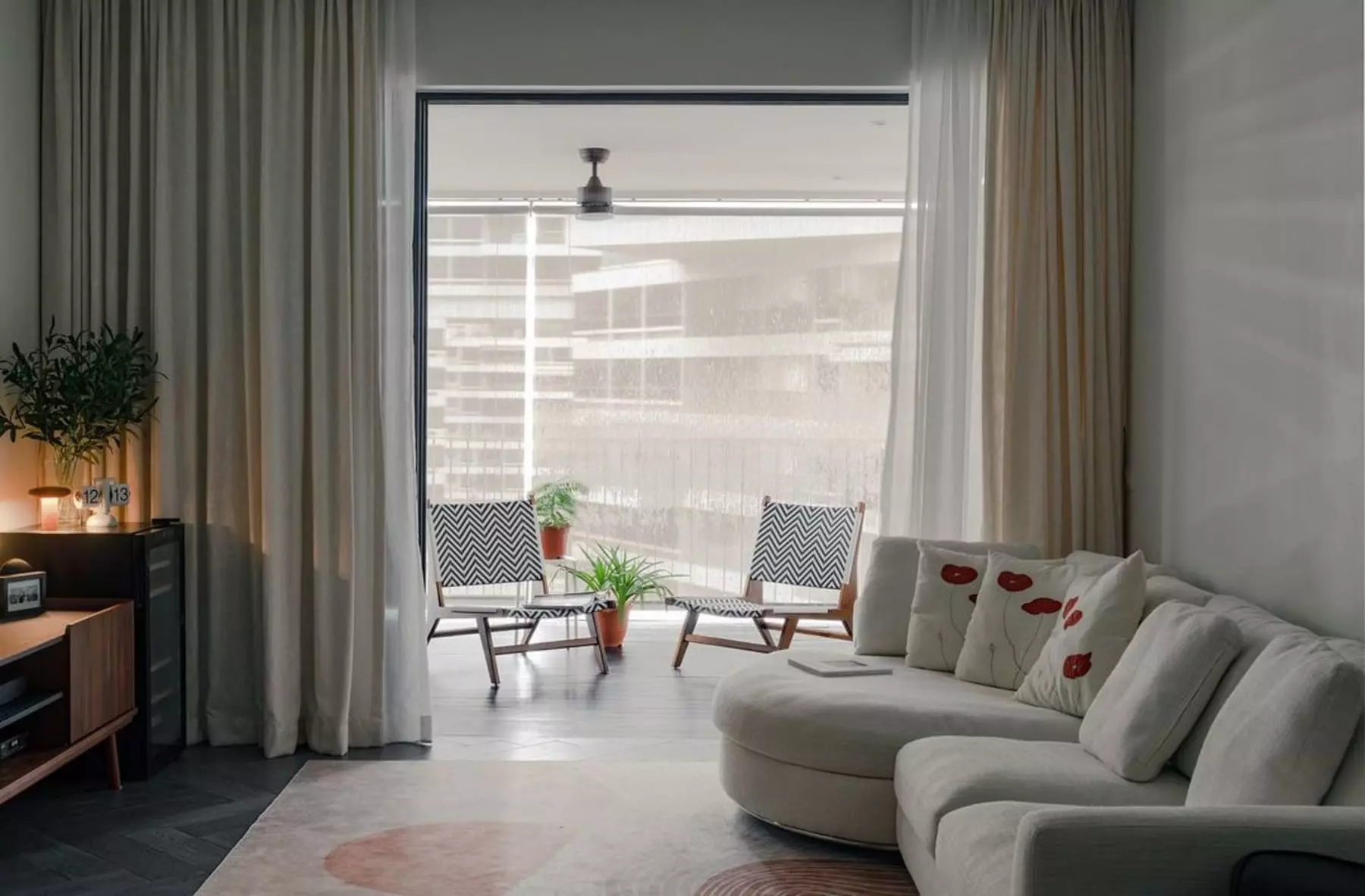 A living room with its doors open to a balcony.