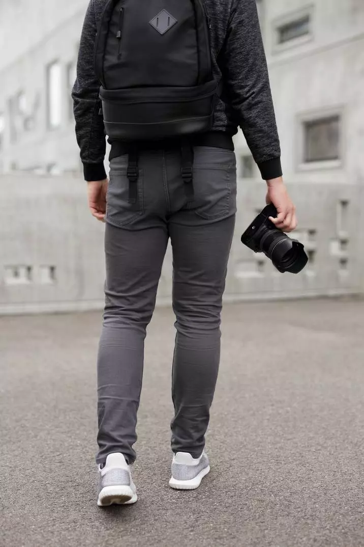 A male photographer outside an unpainted building