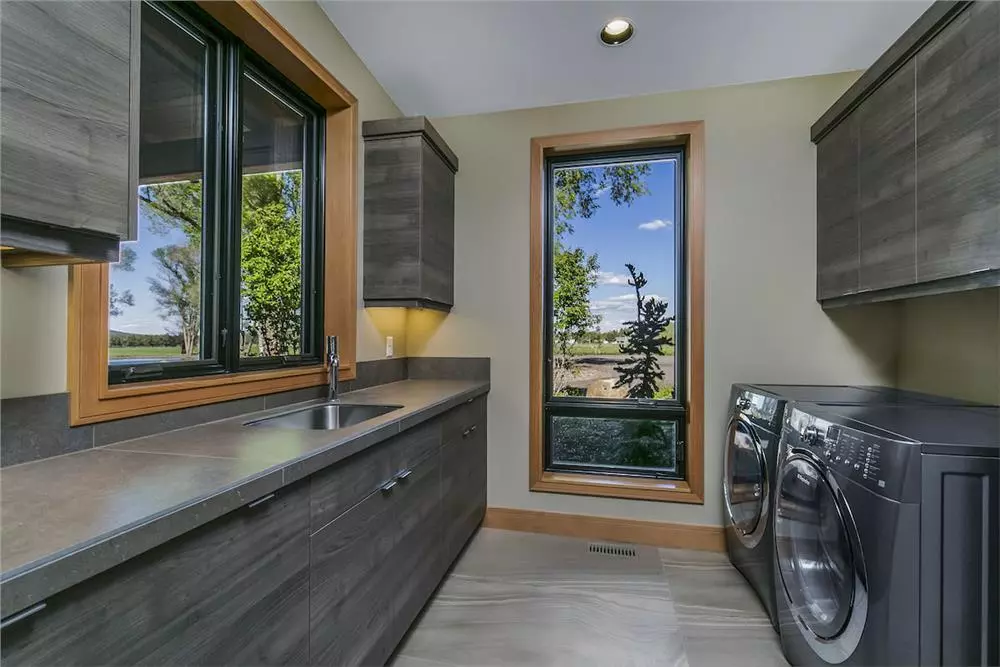 Oversize laundry room in Modern style with sink and cabinetry for storage