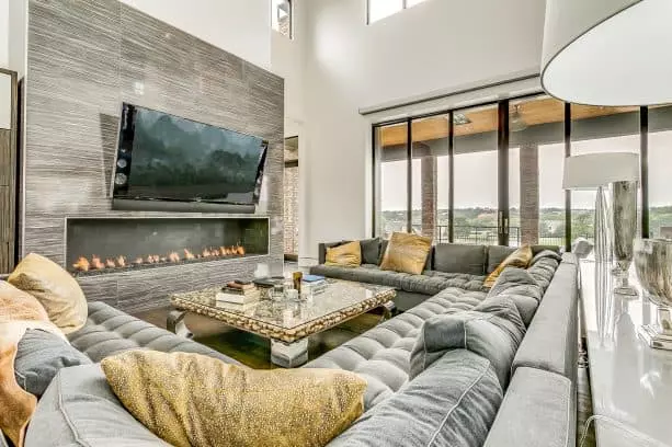 trendy living room with a huge sectional gray sofa and gold throw pillows