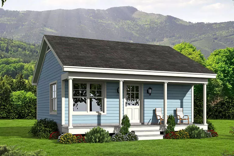 A gray cottage tiny home with white trim and dark gray shutters