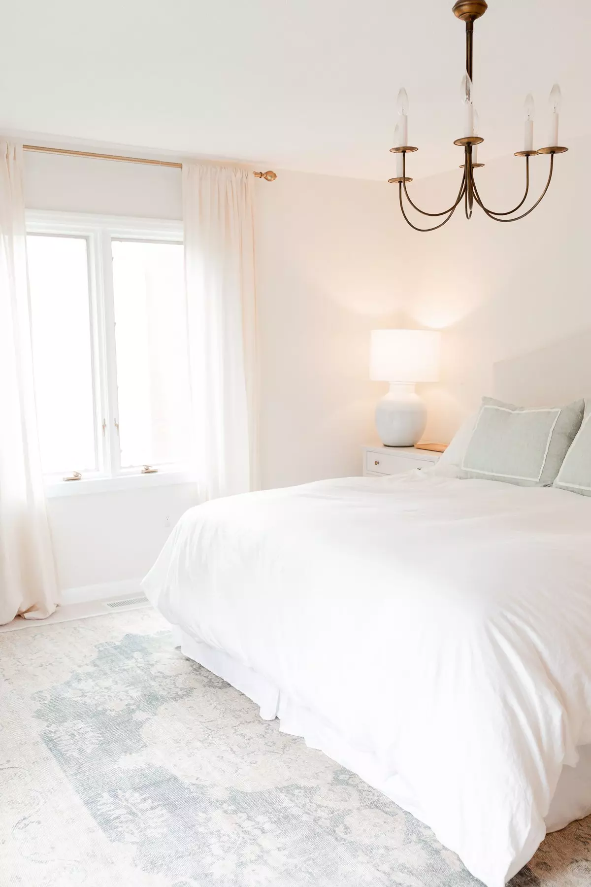 A bedroom with a vintage rug under a king-size bed.