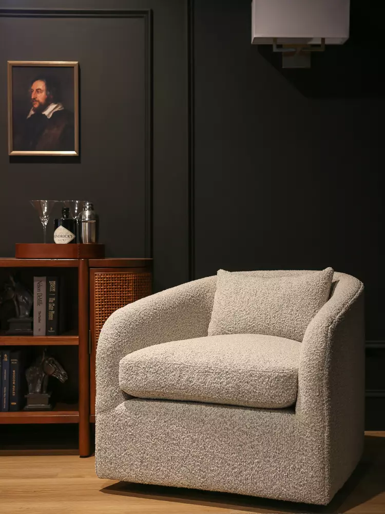 view of white living room with pair of white boucle chairs, two velvet sofas, fireplace all with builtins around tv