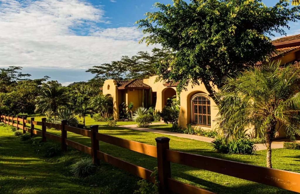 Outside photo of the exterior of a house from behind a small fence