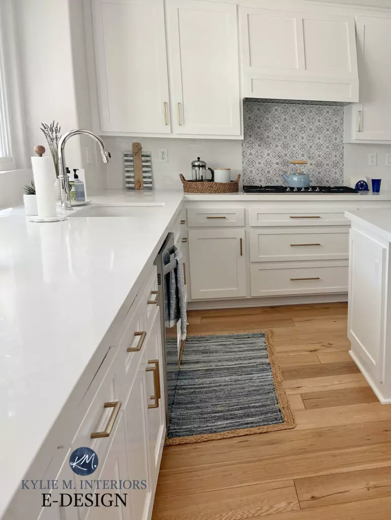 Pure White kitchen cabinets, subway tile backsplash, white quartz, and oak flooring. Navy blue island Sherwin Williams Cyberspace, prep bar station.