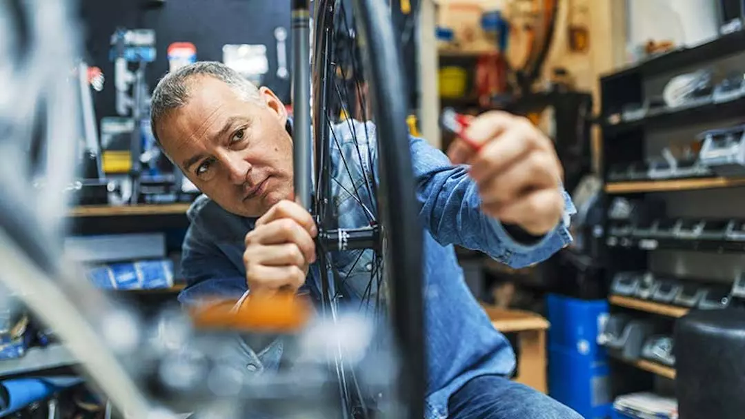 A man works on a tire in his bicycle shop