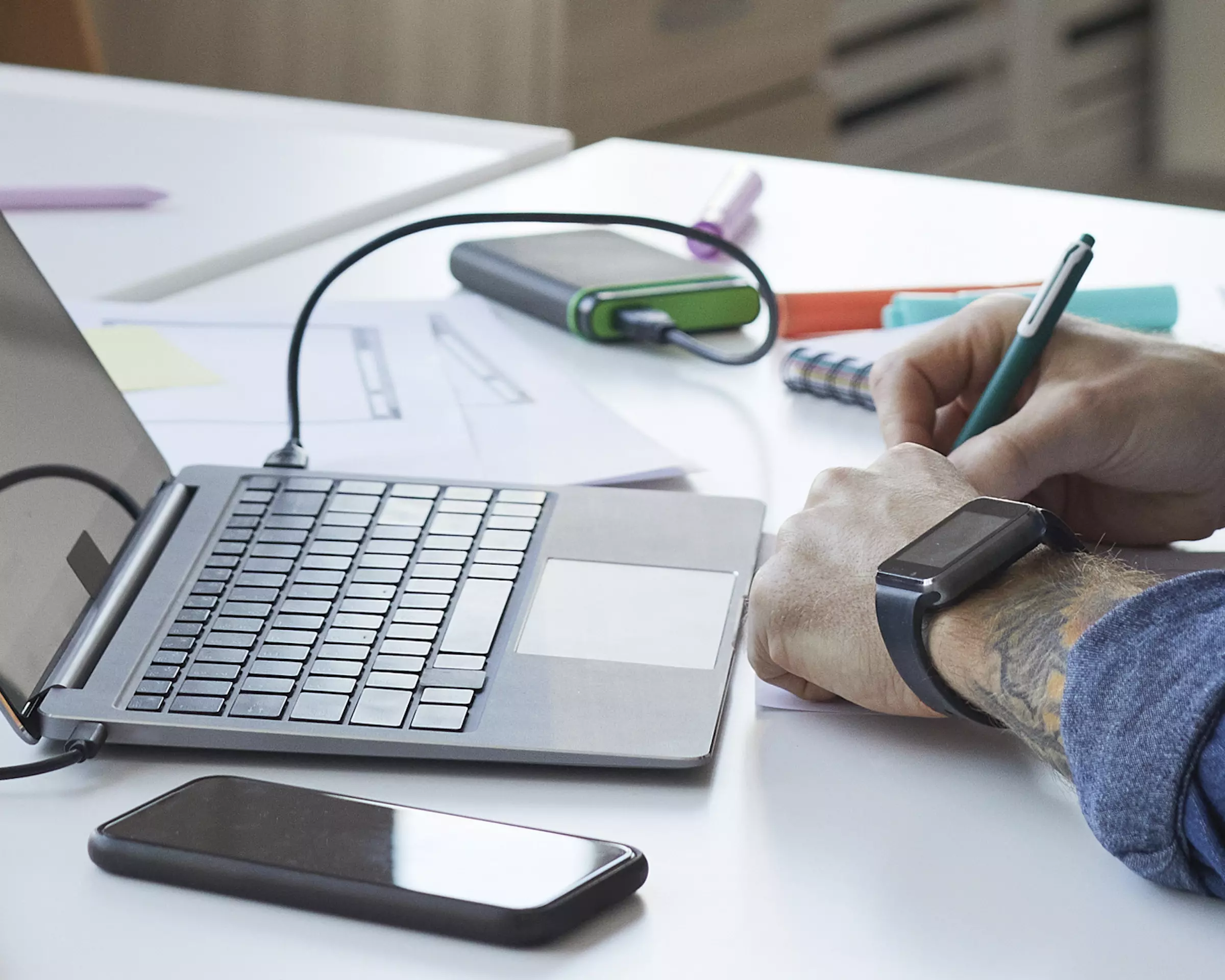 A business owner reads an email from a client and takes notes